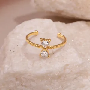 Gros plan d'une bague nœud dorée avec pierres en zircone sur un anneau texturé