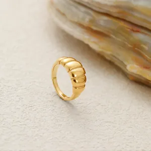 Detalle de la textura acanalada dorada pulida de este anillo grueso de acero inoxidable.