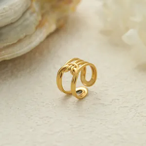 Primer plano de un anillo ajustable de acero inoxidable dorado con diseño trenzado