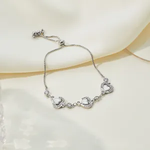 Close-up detail of silver stainless steel heart-shaped mother-of-pearl bracelet with zirconia