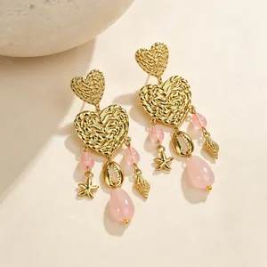 Detailansicht der Herzohrringe mit rosa Perlen und goldenen Meeresmotiven wie Seesternen