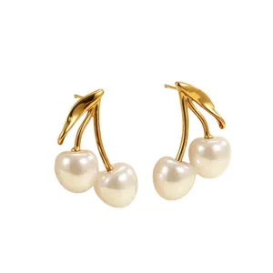 Elegant retro gold cherry earrings with white pearl fruit design on clean white background.