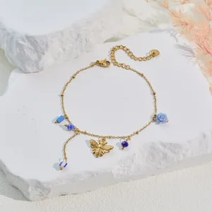 Detailansicht eines vergoldeten Armbands mit blauen Emaille-Blüten und Bienenanhängern