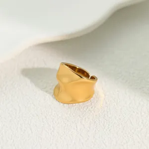 Macro detail of a minimalist irregular wavy gold stainless steel open ring with texture