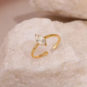 Gros plan d'une bague dorée torsadée élégante sertie d'un zircon transparent de taille marquise.