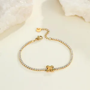 Detailansicht eines minimalistischen goldenen Edelstahl-Tennisarmbands mit edlem X-Anhänger