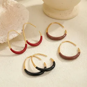 Detailed view of vintage enamel C-shaped hoop earrings featuring red, brown and black tones.