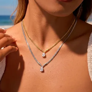 Primo piano di catene a serpente in oro e argento con pendenti in zircone a goccia.