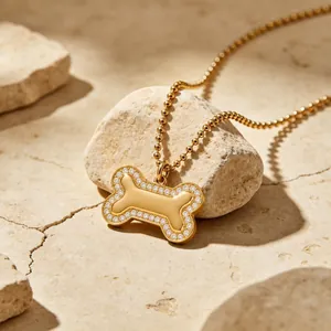 Gros plan sur un collier avec pendentif en forme d'os en acier et cristaux brillants
