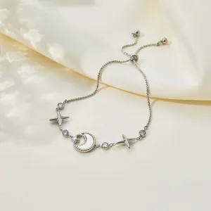 Detail shot of adjustable stainless steel bracelet with shell moon and zircon star charms.