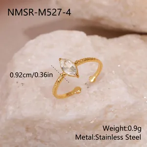 Vue détaillée d'une bague ajustable dorée torsadée avec une pierre zircon marquise