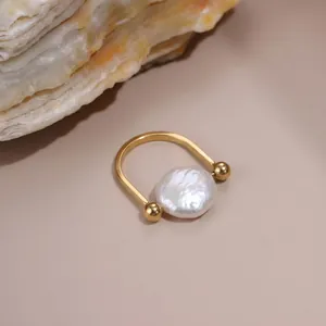 Détail exquis d'une bague minimaliste en or avec une perle baroque blanche naturelle