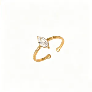 Détail d'une bague torsadée dorée ornée d'un zircon transparent de taille marquise éclatant