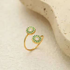 Detail eines vergoldeten offenen Rings mit grünen Emaille-Gänseblümchen und Zirkonia.