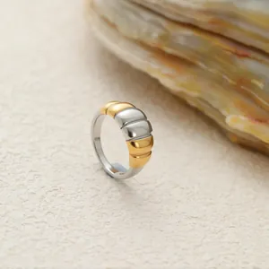 Detalle macro de la textura acanalada bicolor oro y plata de este anillo de acero
