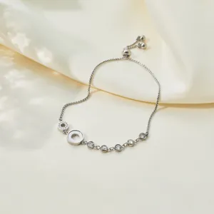 Detail of silver stainless steel adjustable bracelet with zirconia and mother-of-pearl