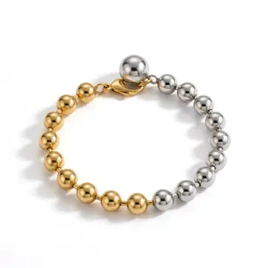Detailed view of a minimalist gold and silver two-tone beaded bracelet with lobster clasp