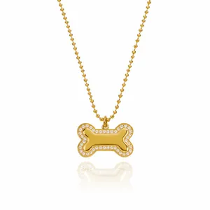 Gros plan d'un collier pendentif os doré avec des bordures en strass étincelants