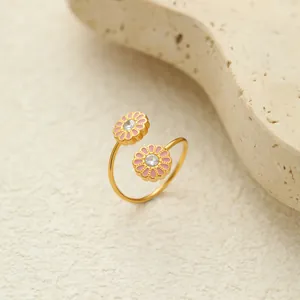 Detailansicht eines vergoldeten Edelstahlrings mit rosa Gänseblümchen-Anhängern