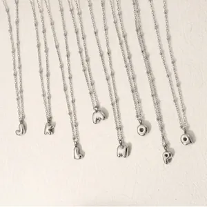 Detail of silver stainless steel ball chain necklaces with 3D bubble letter pendants