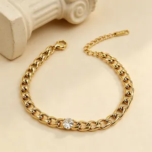 Λεπτομερής προβολή επίχρυσου βραχιολιού Cuban link με κεντρικό διαφανές ζιργκόν