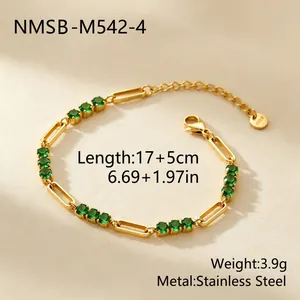 Detail eines vergoldeten Edelstahl-Büroklammerarmbands mit grünen Zirkonia-Steinen.