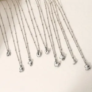Detailed view of several stainless steel bubble letter necklaces with silver bead chains