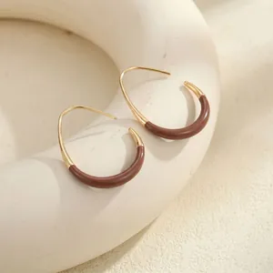 Detailed close-up view of vintage burgundy enamel and gold-plated C-shaped hoop earrings