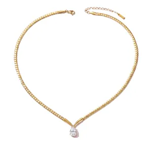 Dettaglio ravvicinato collana a catena serpente dorata con pendente in zircone a goccia.