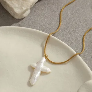 Détail de la chaîne serpent dorée avec pendentif en croix de perle baroque