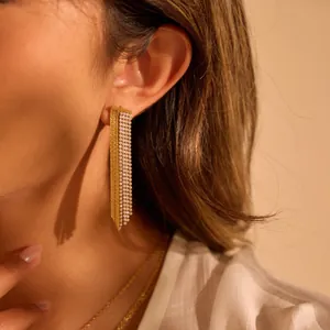Detailed close-up of elegant gold-plated tassel earrings featuring full rhinestone accents