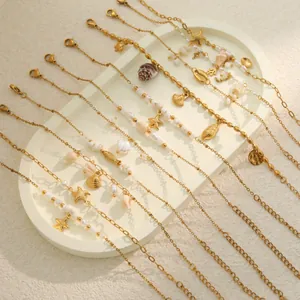 Detail of gold-plated stainless steel bracelets with shells and pearls for summer vacation.