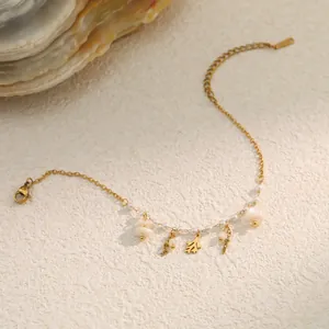 Detailed view of a gold stainless steel bracelet with shells and pearls for summer vacation