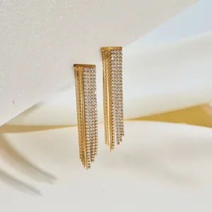 Detailed shot of golden stainless steel tassel earrings with sparkling rhinestones