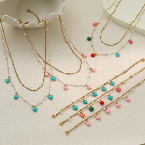 Detailansicht von Gold-Edelstahl-Schmuckset mit bunten Emaille-Herzen und Perlen