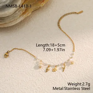 Macro detail of a stainless steel bracelet featuring dainty shell and pearl charms