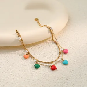 Detailansicht eines goldenen Doppelkettenarmbands mit bunten Herzen und Perlen