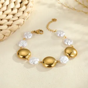 Detailed view of the gold-plated metal discs and baroque pearls on a luxury bracelet