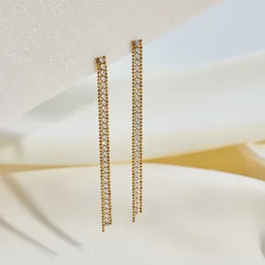 Macro detail view of elegant gold stainless steel tassel earrings with sparkling rhinestones