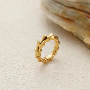 Vista detallada de un anillo de acero inoxidable dorado con diseño de bambú y acabado pulido.