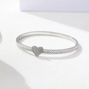 Close-up of a silver stainless steel heart bracelet with sparkling inlaid crystals