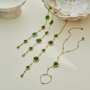 Vista detallada de pulseras de acero de titanio con circonitas verdes y corazón.