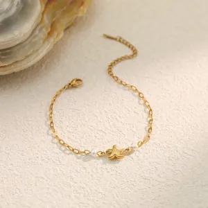 Detail view of gold stainless steel bracelet with starfish charm and white pearls