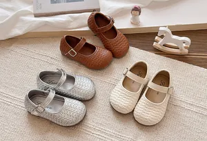 Detalle de la textura tejida de los zapatos Mary Jane para niñas en marrón plata y crema