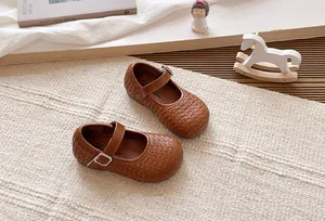 Elegantes manoletinas Mary Jane trenzadas en marrón para niña con estilo francés clásico.