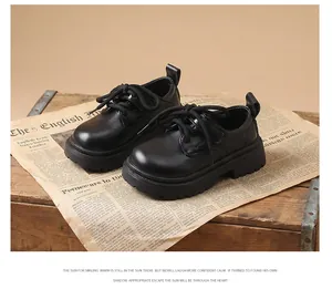 Close-up of boys' black leather British-style shoes with thick soles on a vintage crate