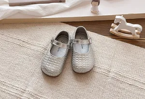 Detalle de zapatos de princesa Mary Jane trenzados plateados para niñas con hebilla.