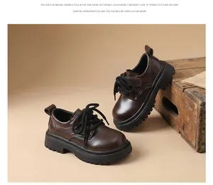 Detailed view of dark brown boys' British style leather shoes with chunky black soles.