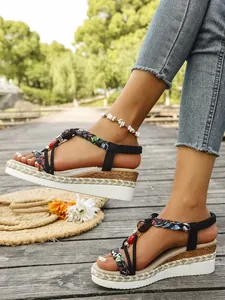 Close-up of Bohemian wedge sandals featuring floral braided straps and colorful beaded detail