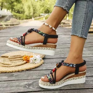 Close-up of Bohemian ethnic wedge sandals with colorful beads on a wooden deck